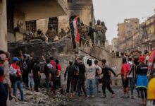متظاهرون في ساحة التحرير ببغداد يرفعون الأعلام العراقية ضمن حراك شباب تشرين