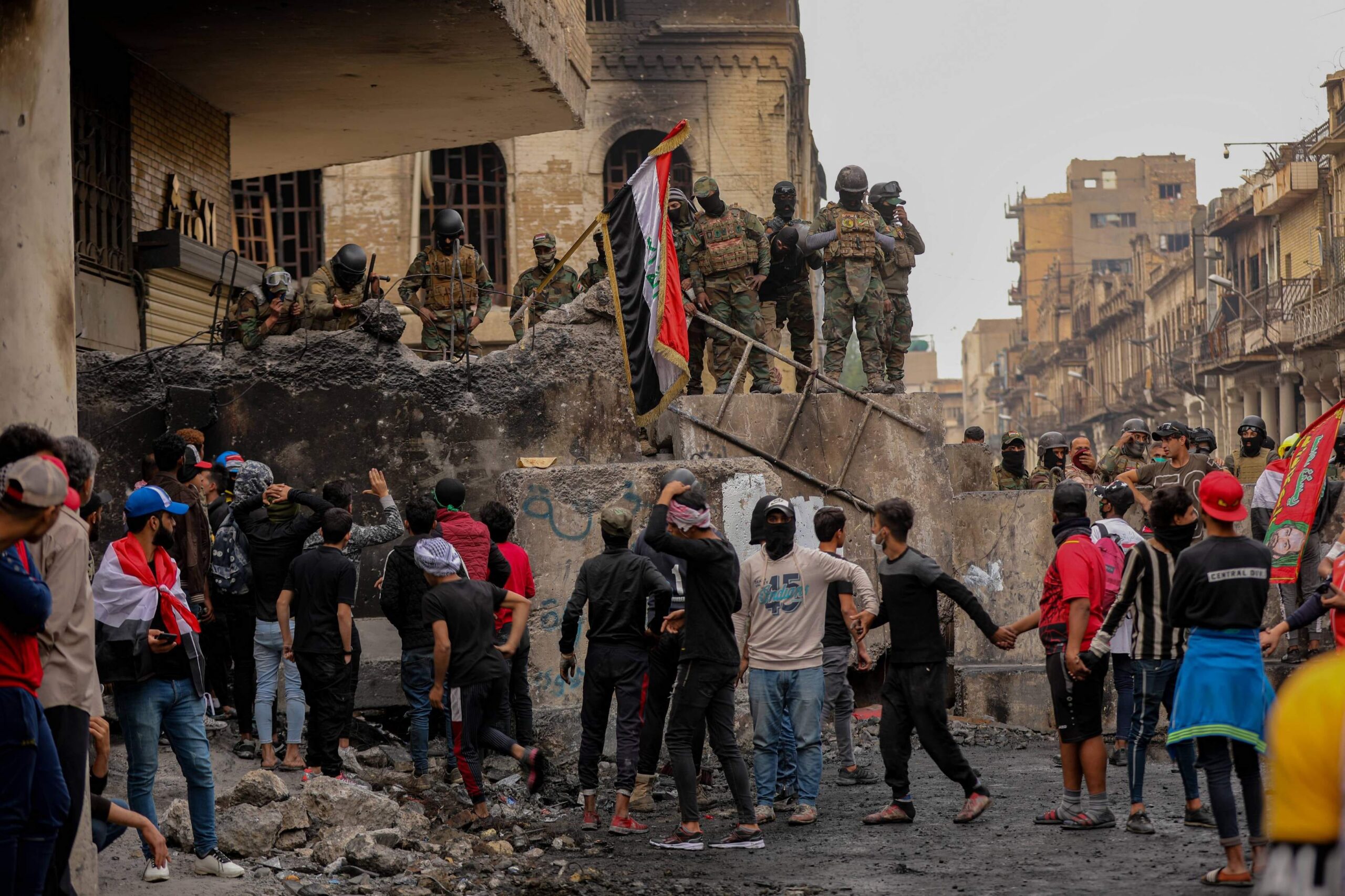 متظاهرون في ساحة التحرير ببغداد يرفعون الأعلام العراقية ضمن حراك شباب تشرين
